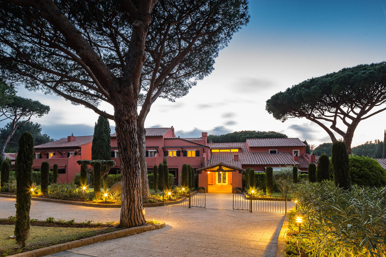 Blick auf toskanisches Haus umringt von Bäumen in Abendstimmung