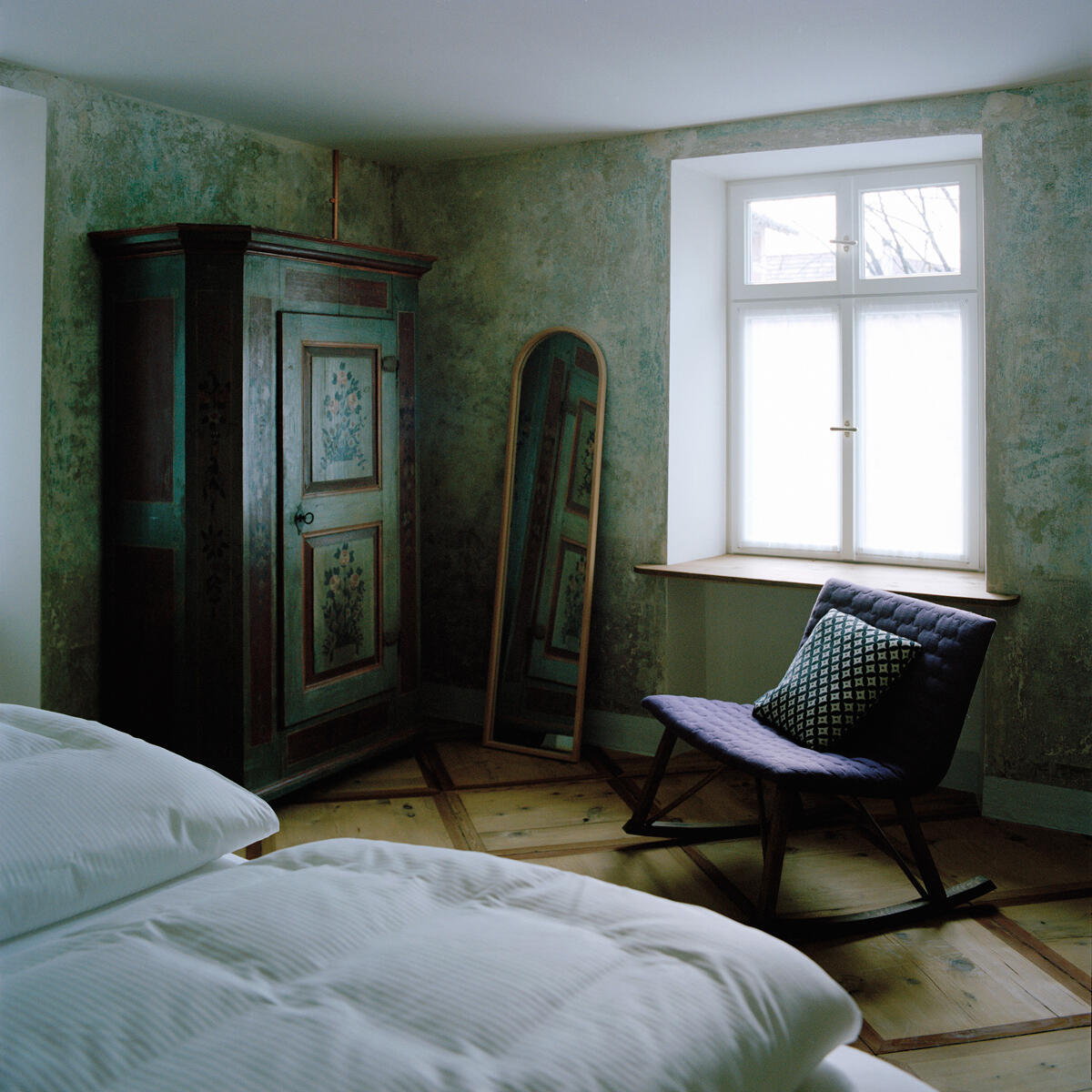 Schlafzimmer im Steinach Townhozse mit grünen Wänden und antiken Möbeln